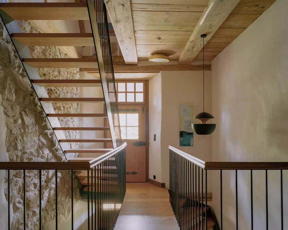 Neue Treppe aus Schwarzstahl mit Kirschbaumtritten an der freigelegten Bruchsteinmauer