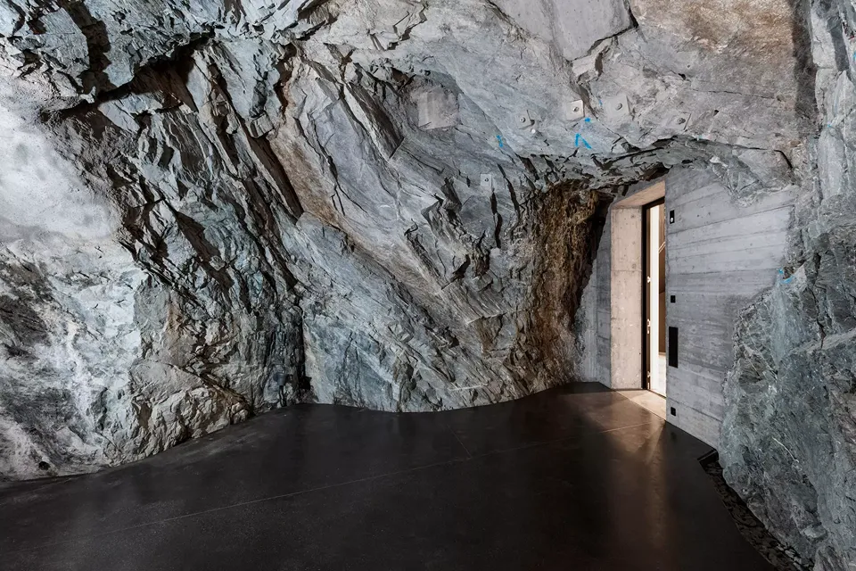 L’entrepôt caverneux de  la brasserie transformé  en grotte muséale. La découpe hasardeuse des parois naturelles est mise en valeur par le coffrage  du béton et le joint creux sinueux du terrazzo le  long des parois.