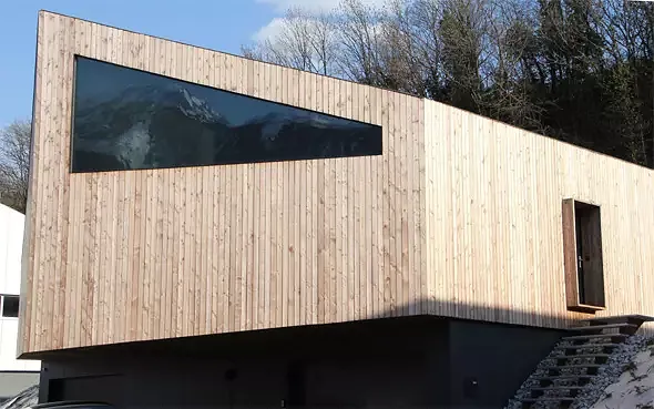Vue nord-ouest: L'escalier d'accès formé de grilles caillebotis posée sur deux plaques en acier sur la tranche a été conçu de manière à ne touche pas toucher le volume en bois. L'embrasure de 50cm forme ainsi la dernière marche, un petit couv