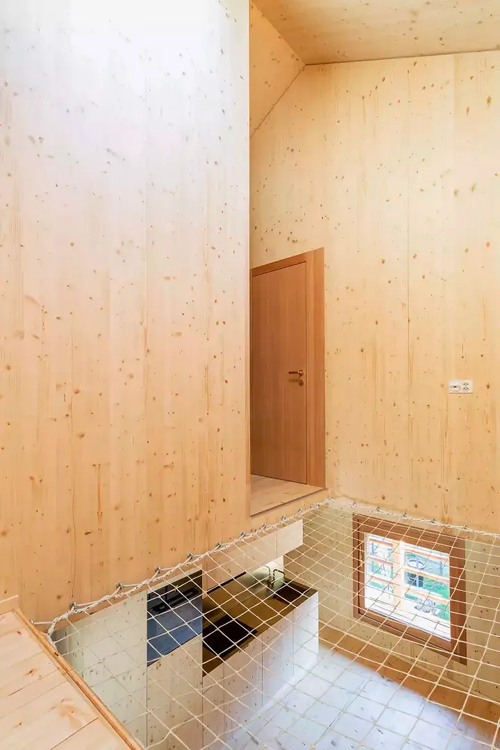 In Anlehnung an die vertikale Struktur des ehemaligen Heustadels durchbricht die doppelte Deckenhöhe in der Küche beide Obergeschosse und sorgt in diesem schmalen Bau für mehr Weite und ein besseres Raumgefühl.