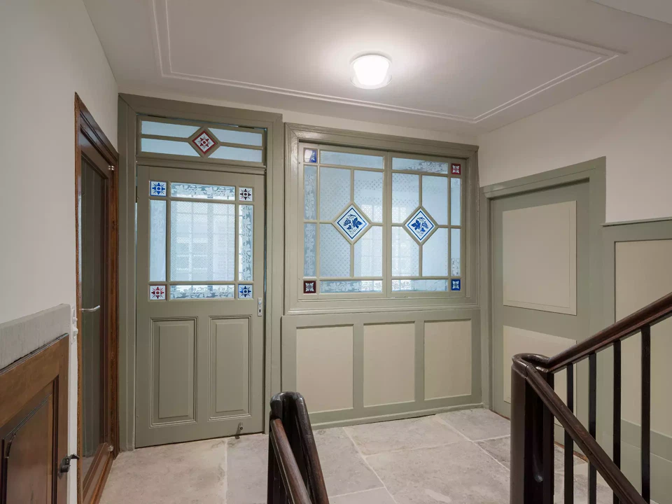 Treppenhaus mit restaurierte Bleiverglasung und Wandtäfer