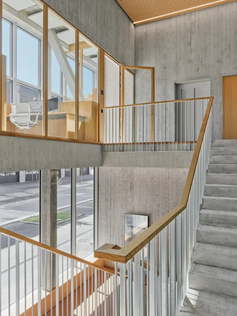 La cage d'escalier, qui s'étend sur toute la hauteur du bâtiment, est baignée de lumière naturelle grâce à sa grande façade vitrée.