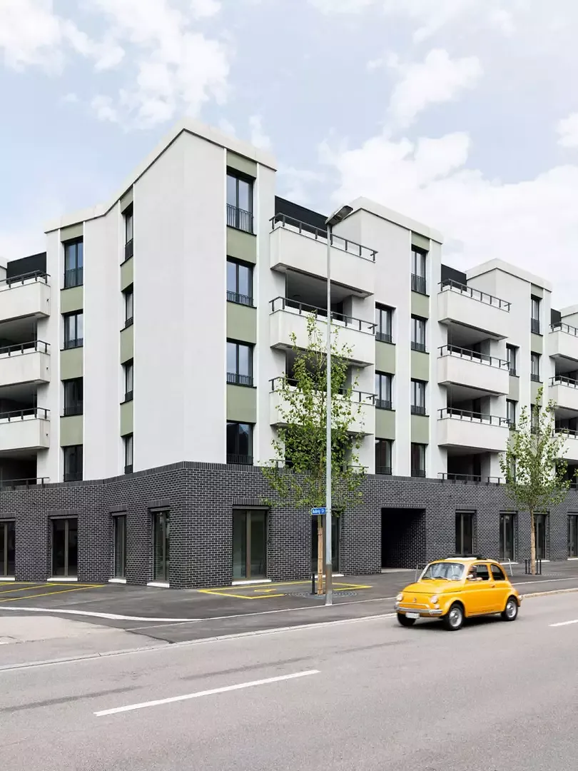 Sockel, Dachrand, stehende Fensterformate, reliefierte Flächen und Metallgeländer zitieren Vorbilder aus der europäischen Stadtentwicklung.