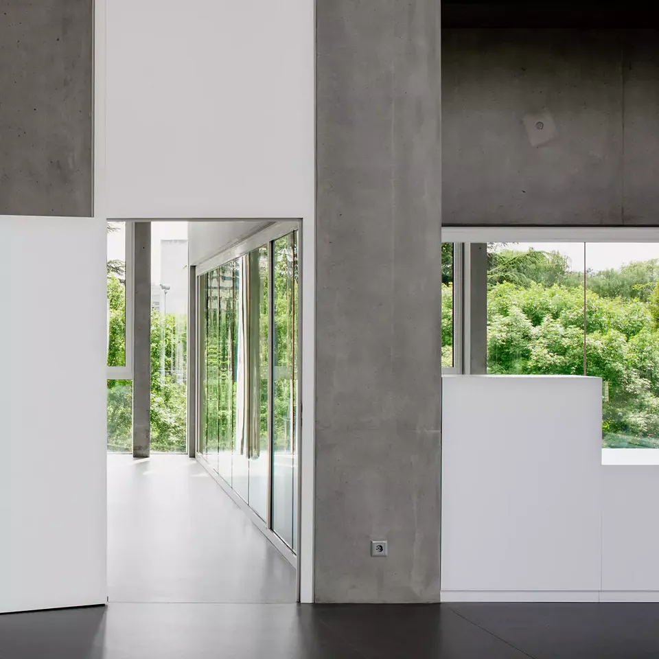À l’intérieur, les architectes jouent sur l’alternance  entre le béton apparent et  les surfaces blanches lisses.