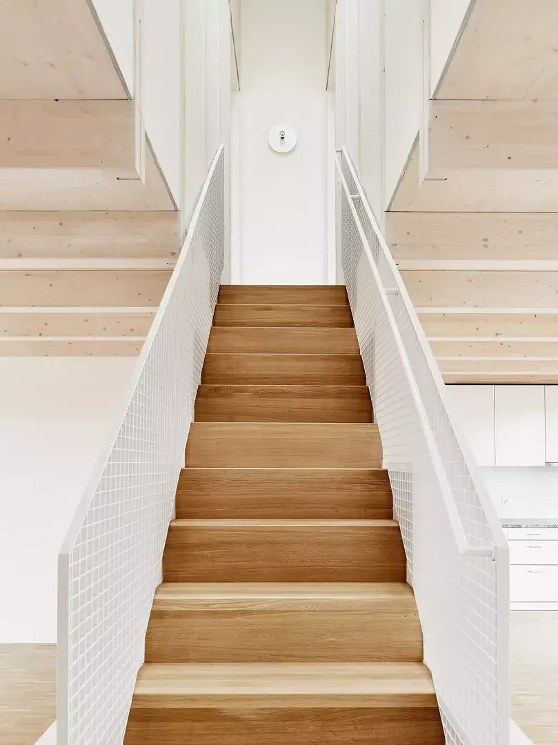 Les deux appartements en  duplex sont conçus comme  des contreparties, réalisées en  bois de construction, lasurées  en différentes teintes (glacis blanchâtre et couleur bois naturel).