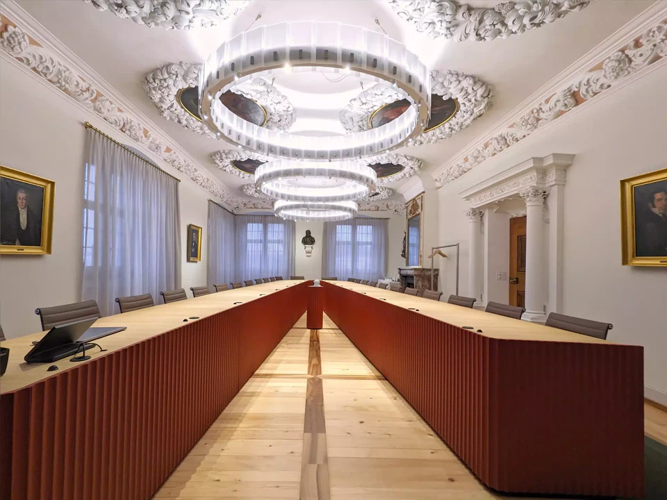 Die unterschiedlich langen Schenkel des Tisches schaffen Raum für Vorträge an der LED-Wall