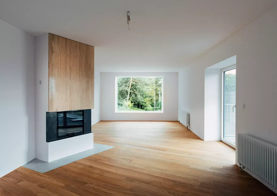 Küche, Ess- und Wohnzimmer wurden zu einem Raum zusammengefasst. Der Kamin etabliert dennoch eine dezente Zonierung.