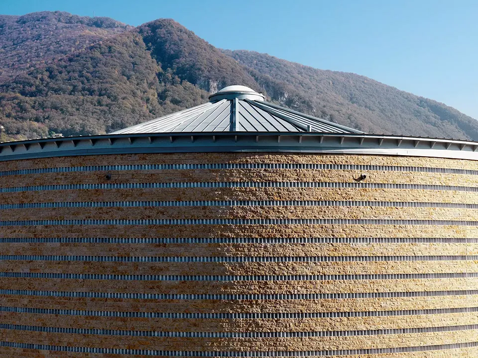 Backstein prägt das  gesamte Gebäude.  Besonders hervorzuheben  ist die Struktur der  Fassade. Goldene Farbe  und die rauhe Maserung  der mineralischen  Oberfläche unterstreichen  die eigentümliche  Identität des Gebäudes.