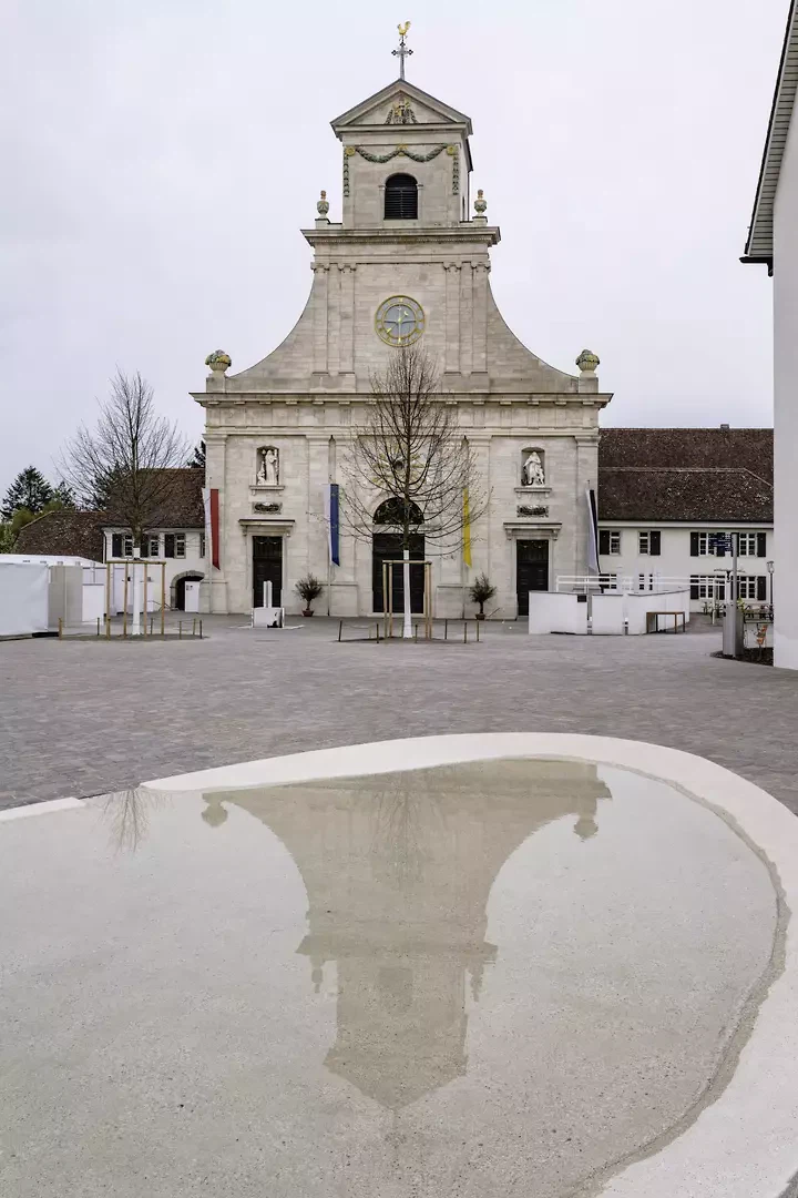 Der Wasserspiegel aus geschliffenem Kunststein aus Jurakies stellt die vierte Leitfigur dar und spiegelt kurz vor der Basilika den «Himmel auf Erden»