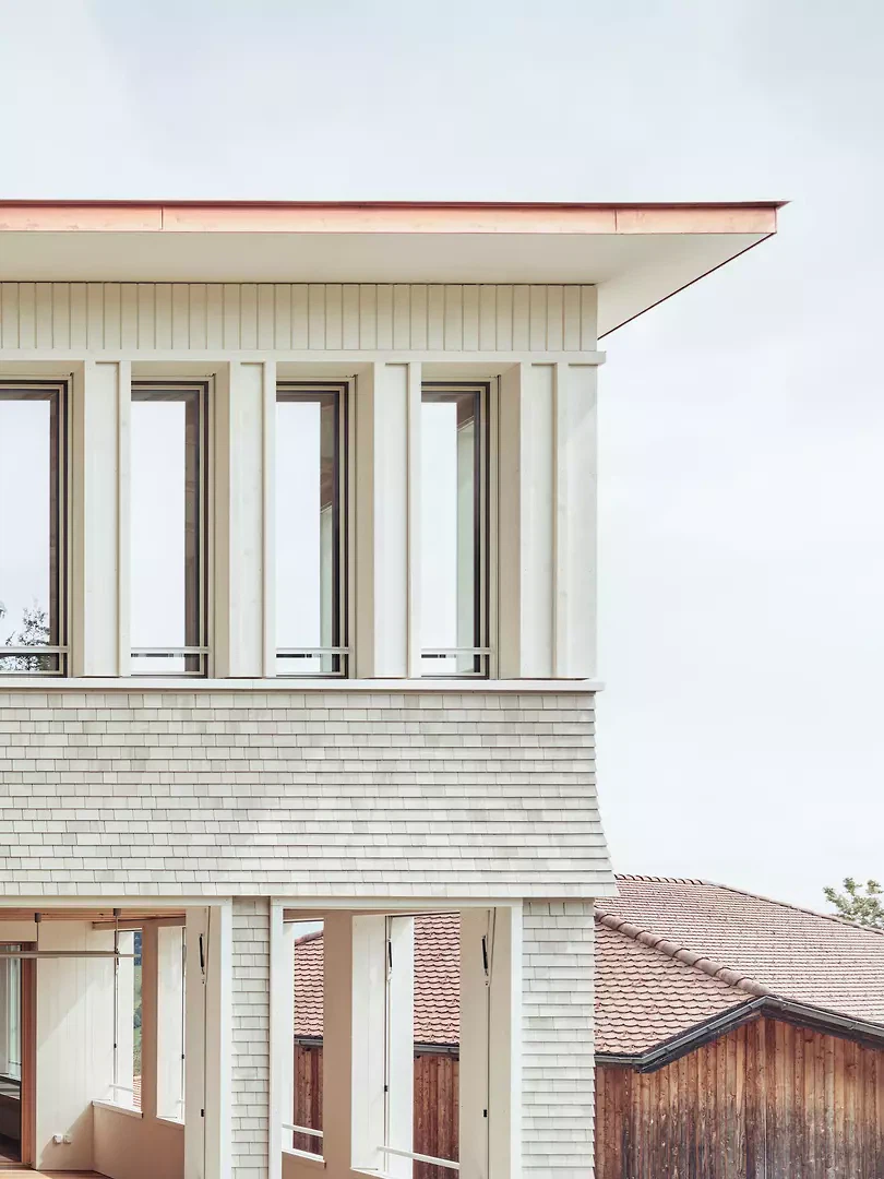 Feingliedriger Holzbau und Schindeln verweisen zum Mansardgeschoss des Hauptgebäudes von 1905