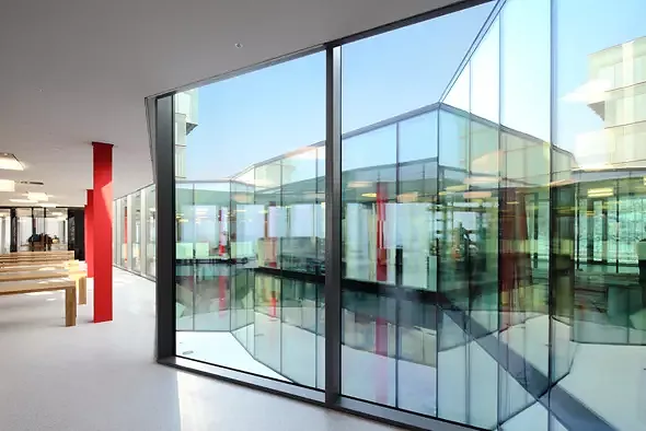 Aussen rechtwinklig und kubisch, gibt sich das doppelgeschossige Atrium polygonal und unregelmässig.