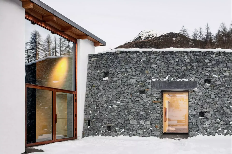 Sur la terrasse intermédiaire principale  se côtoient les murs-façades d’amphibolite  des nouveaux espaces d’exposition et les volumes en maçonnerie enduits de «crépi  de l’Engadine».