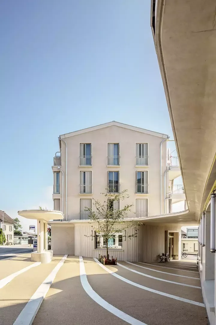 Fassadenansicht Haus B / Dorfplatz mit Bushaltestelle