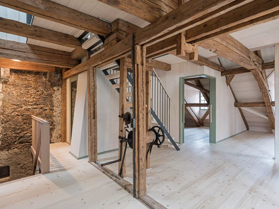 Dachgeschoss, vielschichtige Gefüge aus altem Tragwerk, Bruchsteinwand und neuen Einbauten