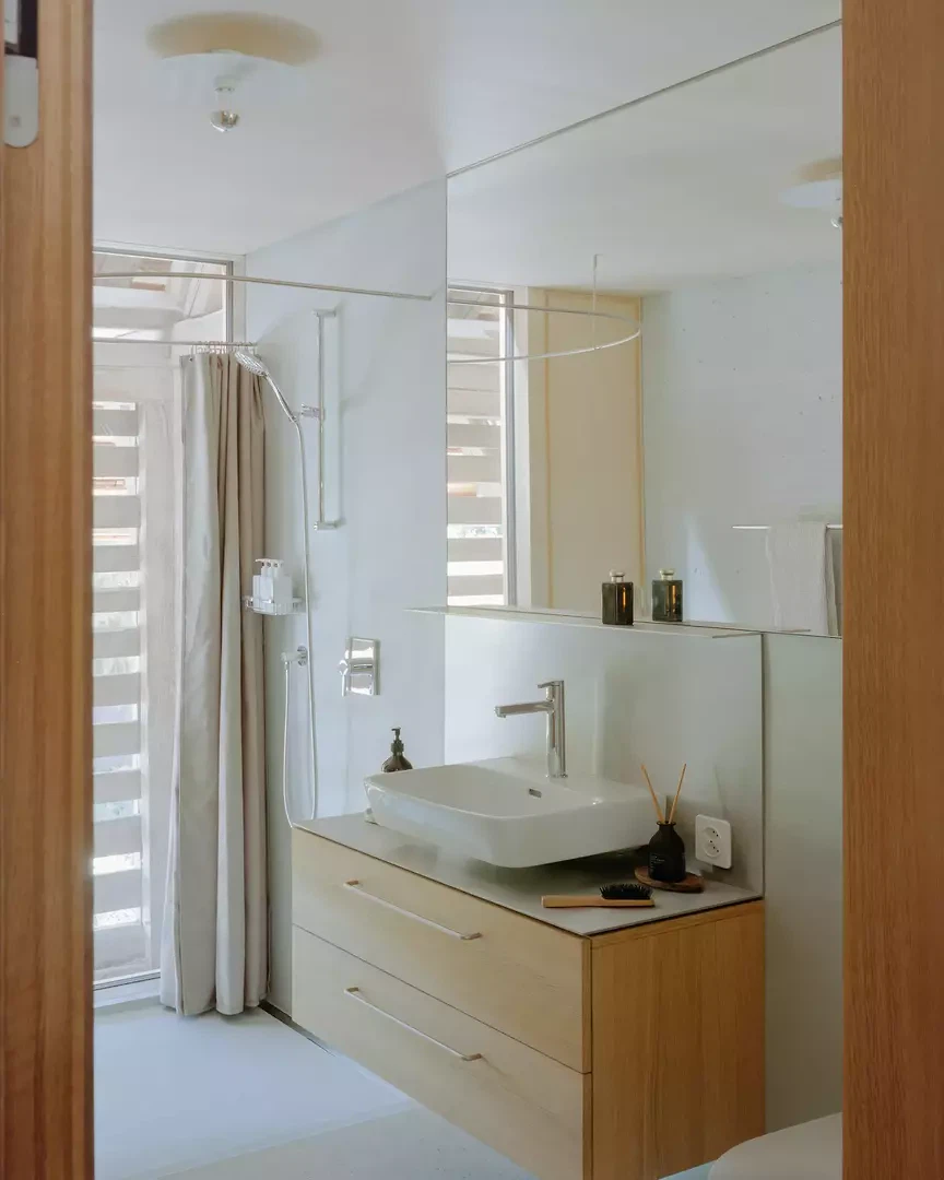 Natürlich belichtetes Bad – die bestehende Gimmwand wirkt als Filter.