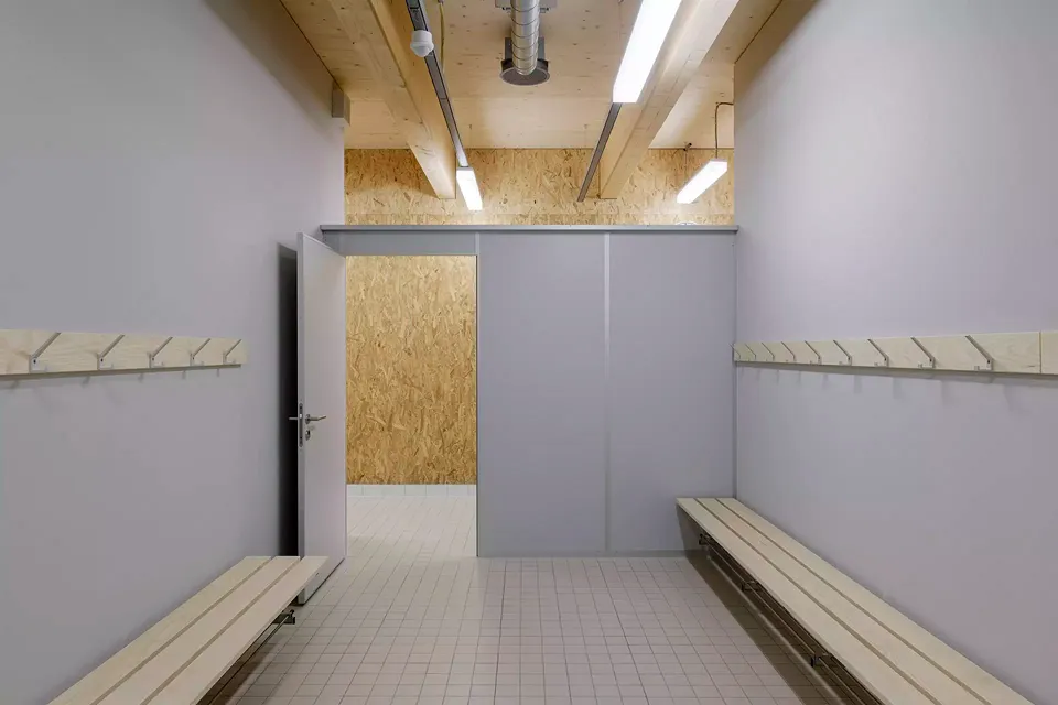 Garderobentrakt in der Turnhalle mit sichtbar bleibender OSB-Verschalung und Deckenkonstruktion