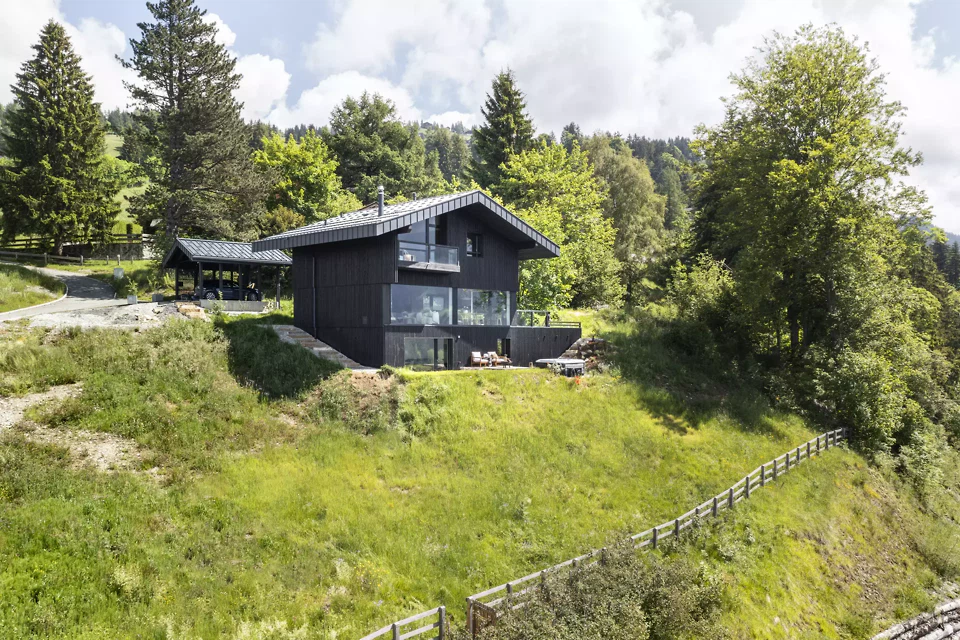 Das Chalet als ruhiger Baukörper in der Topografie verankert