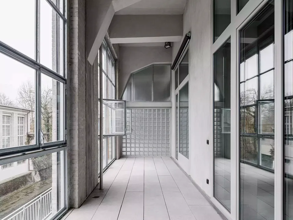 Côté ouest, la création d’une loggia sur toute la longueur fait office de tampon climatique. Cette solution a permis de conserver les fenêtres aux profils fins ou de ne les remplacer que ponctuellement.