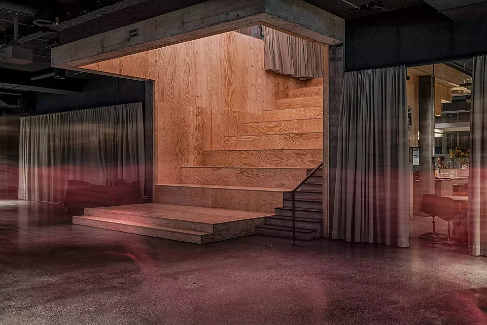 Escaliers: vue du foyer où  se déroule les évènements,  le grand escalier en bois  avec gradins, recouvert de contreplaqué à base de pin maritime.