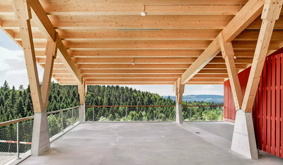 Blick ins Tal vom Unterstand des Gewerbegebäudes mit einer leichten, schützenden Dachkonstruktion aus Holz.