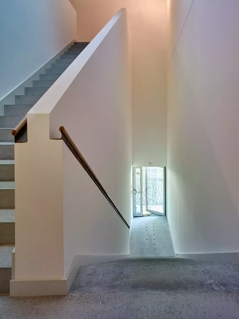 La cage d’escalier  mesure 1,50 m de large.  La finition du garde-corps est une main courante  en acier brut et en chêne  et rappelle un cargo.