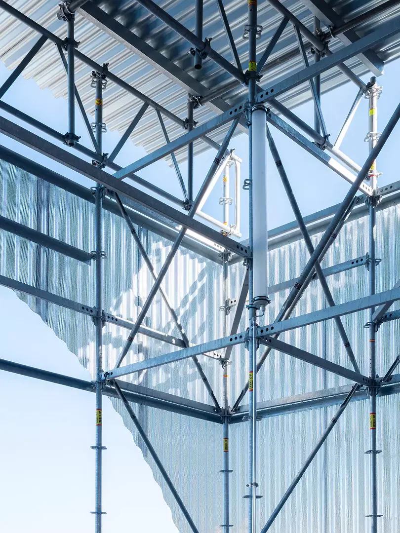 Gewelltes Lochblech aus walzblankem Aluminiumverkleidet den Treppenturm