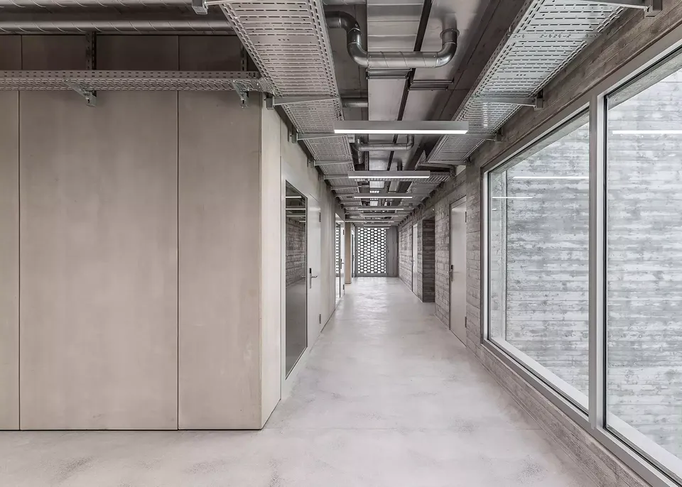 Les murs extérieurs des salles de classe  et le mobilier intégré sont constitués  de panneaux Duripanel. Les panneaux des  vestiaires ont une épaisseur de  19 millimètres et ne sont pas poncés.  Dans la zone du front office, ils sont  poncés et vitrifiés.