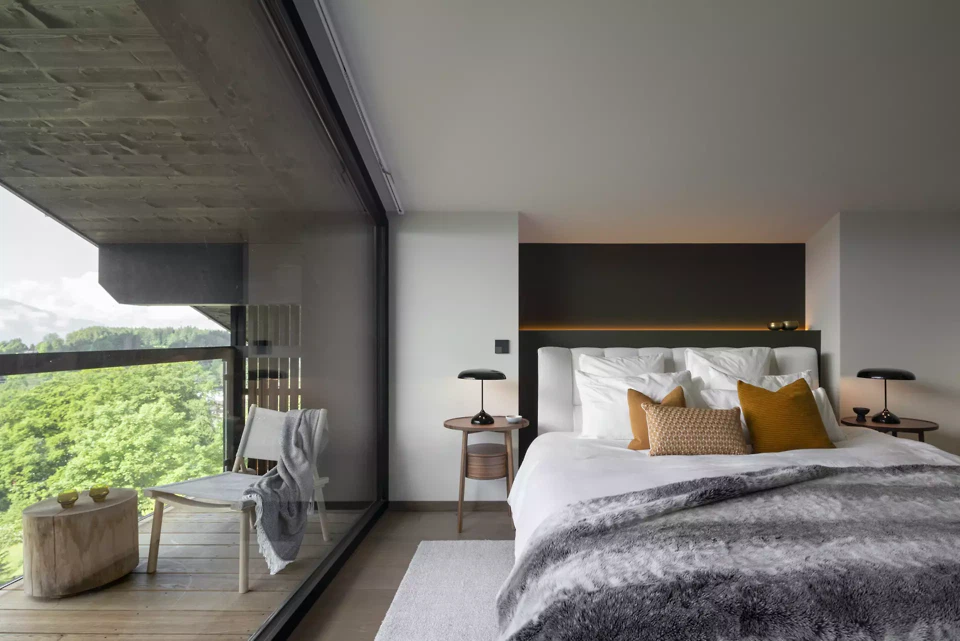 Schlafbereich mit grosszügiger Verglasung und ruhiger Materialpalette