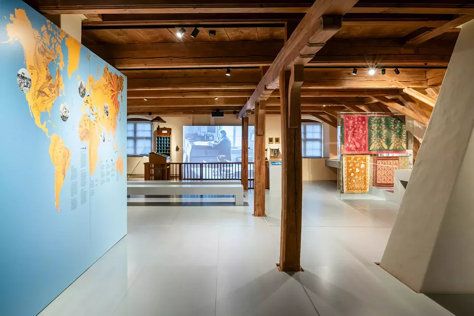 Ausstellungsauftakt bildet eine Karte zu den Erkundungsreisen, auf welchen das nötige Know-how aus aller Welt eingeholt wurde, und den späteren Handelswegen. Im Hintergrund das Kontor.