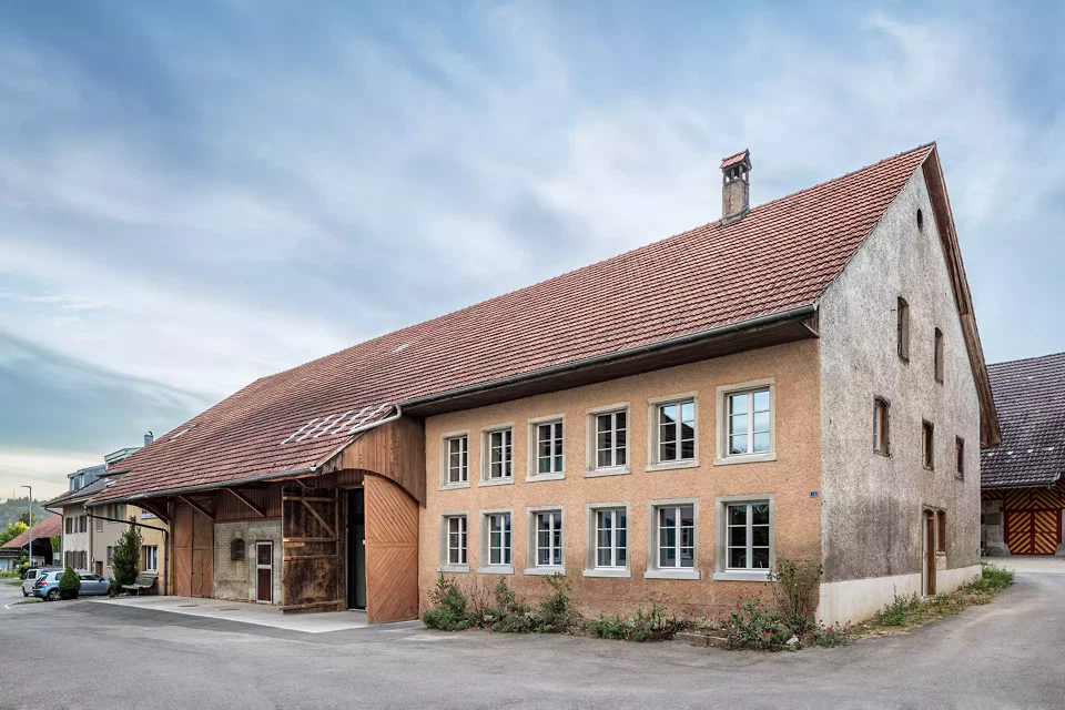Strassenfassade mit erhaltenem Tenntor und erneuerter Verglasung im Bereich des ehemaligen Tenns.