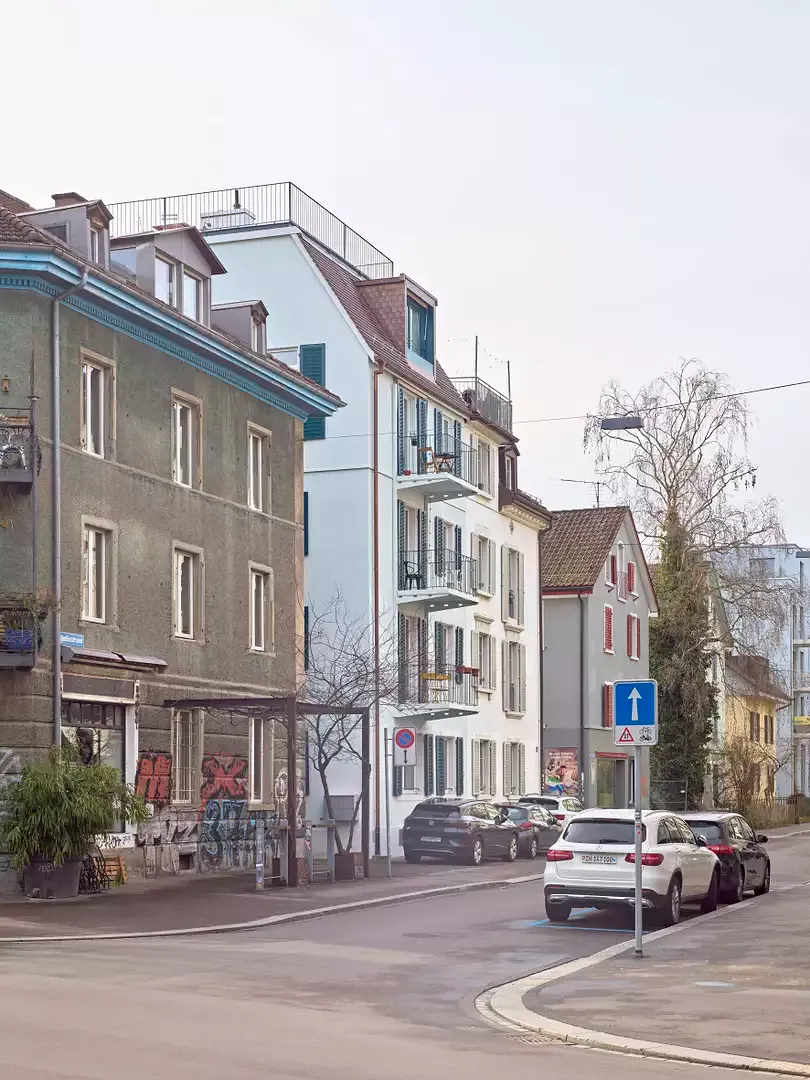 Ein feines Band in der Fassade markiert den Übergang von Alt zu Neu und von Massiv- zu Holzbau.