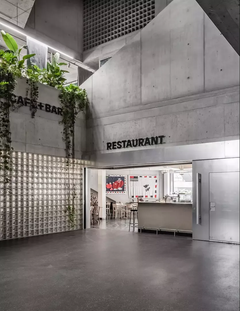 La matérialisation brute  du restaurant, du théâtre et du forum donne l’impression que l’espace de la rue s’écoule à travers le bâtiment.