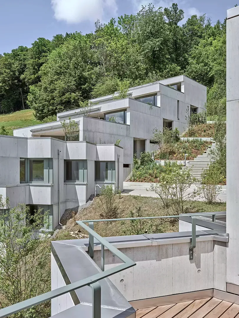 Die Häuserzeilen, die entweder unten oder oben an die Spielstrasse anschliessen, sind so orientiert, dass die dazwischenliegenden Treppen nicht in einer Linie zur jeweils obersten Wohnung führen, sondern auf halber Höhe verspringen