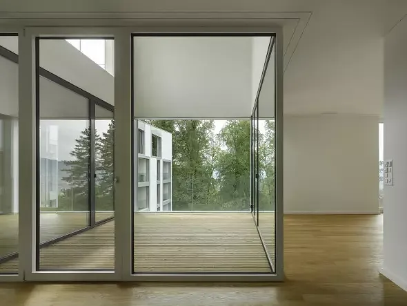 Während das Gebäude aussen von einer straffen Haut umspannt wird, öffnen sich die Wohnungen im Inneren. Durch Aus- und Durchblicke entsteht räumliche und visuelle Grosszügigkeit.