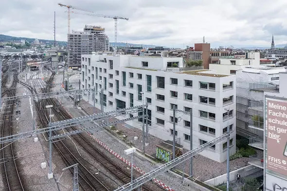 Das Wohnhaus steht am Rande des Gleisfelds und schmiegt sich mit seiner leichten Wölbung daran an.