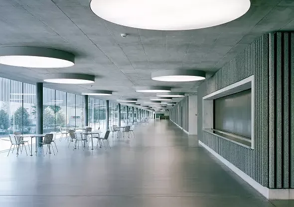 Langgestrecktes Foyer als Ersatz des fehlenden Aussenraums macht horizontale Dimension des Gebäudes im Innern erfahrbar