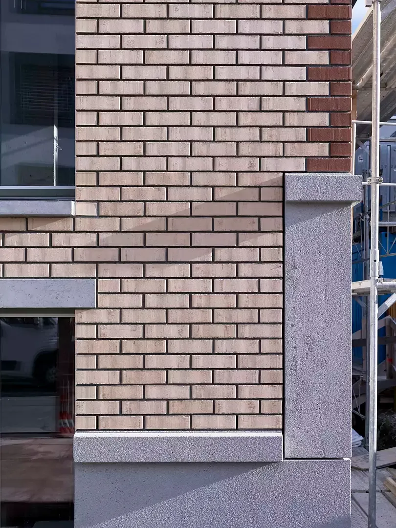Façade en brique et éléments en béton avec surfaces sablése