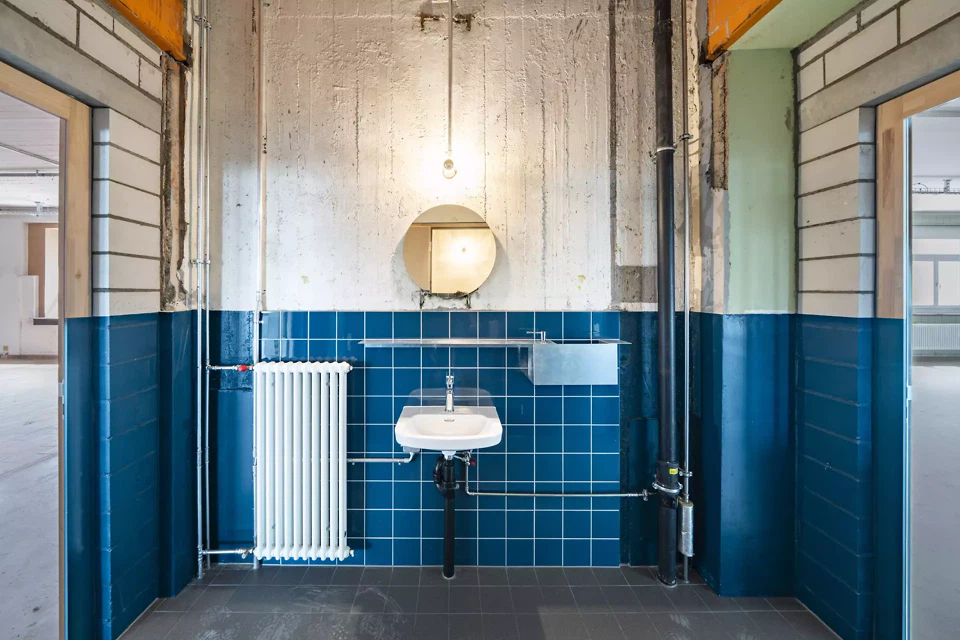 Dans les nouveaux  sanitaires – situés en partie dans les anciennes cages d’ascenseur – le choix des carreaux s’est fait en fonction des palettes de couleurs des cages d’escalier.