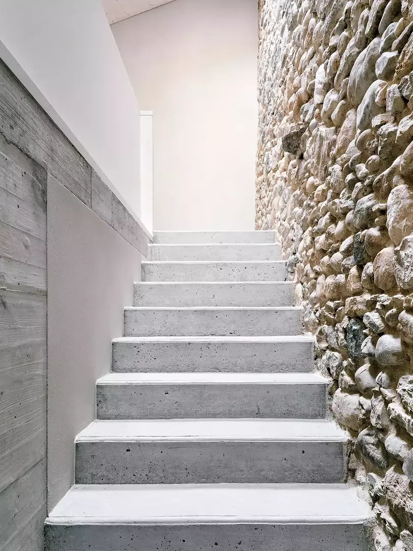 Escalier menant à la mezzanine, mur existant en pierres