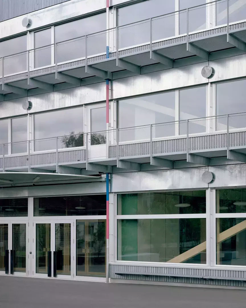 Holzmetallfassade mit farbigen Regenrohren