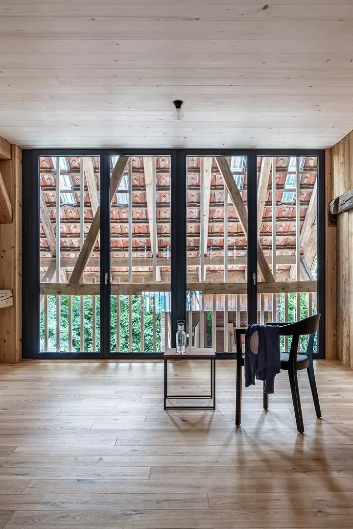 Verglasung hinter dem historischen Tenntor, Blick auf die Dachkonstruktion der Scheune.