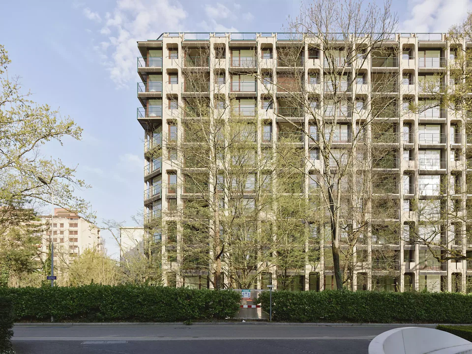 Die aussen sichtbaren Betonrahmen geben dem Gebäude eine vertikale Anmutung. Die rhythmische und symmetrische Gliederung der Fassaden wurde beibehalten. Die Fensterrahmen wurden, wie ursprünglich, dunkelbraun thermolackiert.