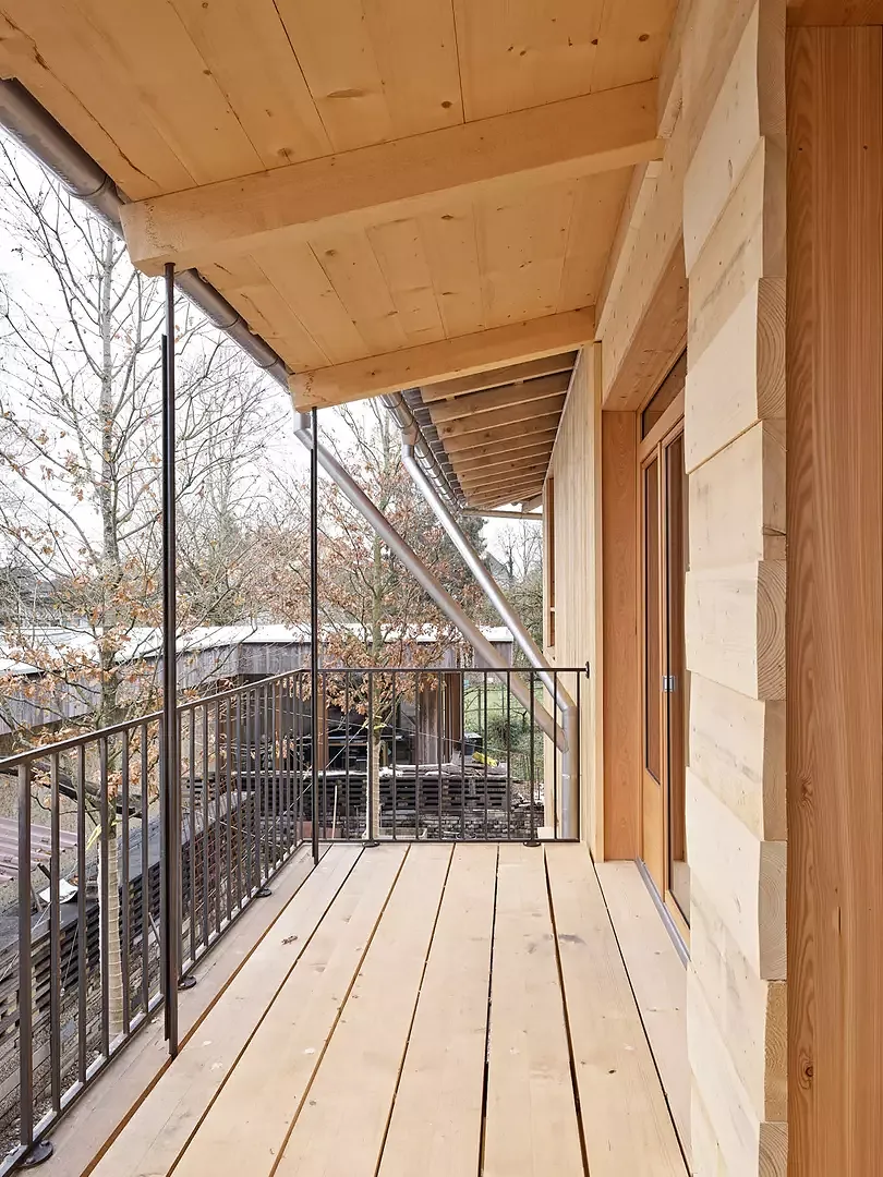 Südseitiger Balkon im 1.OG. Die textilen Momente der robusten Fichtenschalung sind in den Fassadenöffnungen wahrnehmbar.