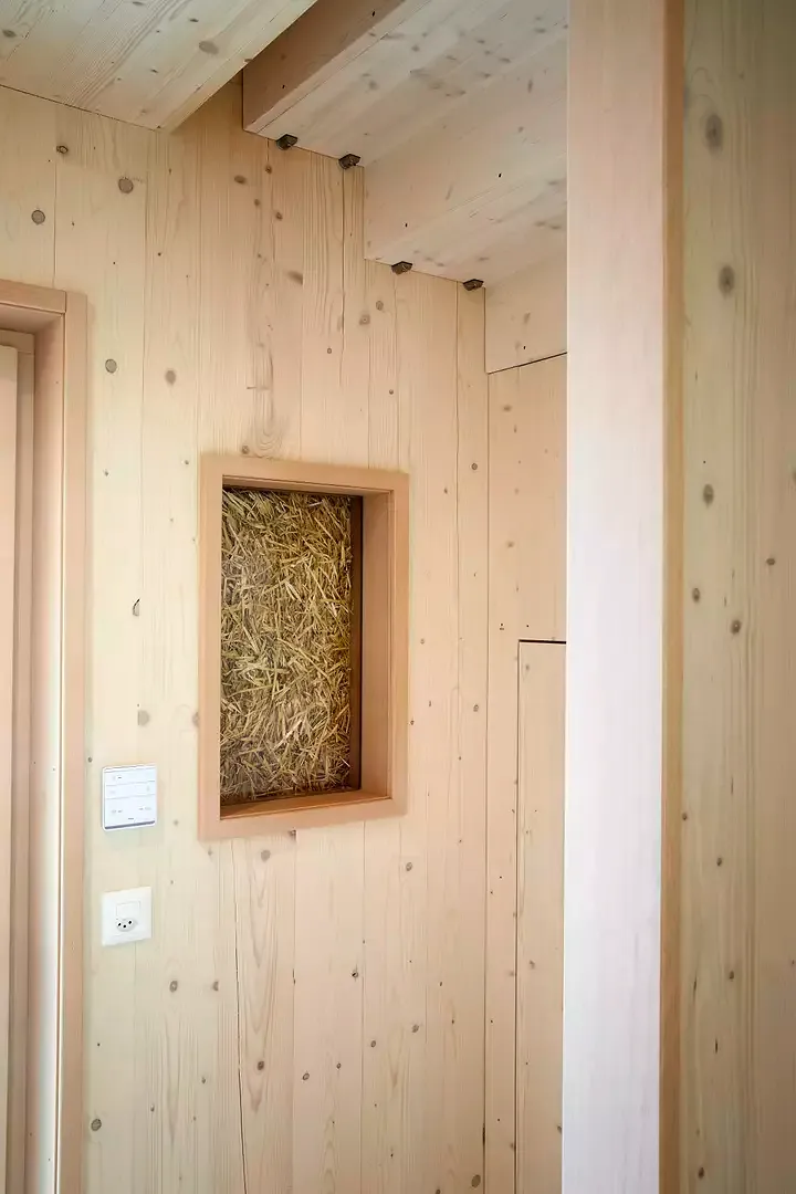 Treppen aus Holz verbinden die Ebenen in den Reihenhäusern. Dort machen «Fenster» in die Dämmebene das Stroh in den Wänden sichtbar.