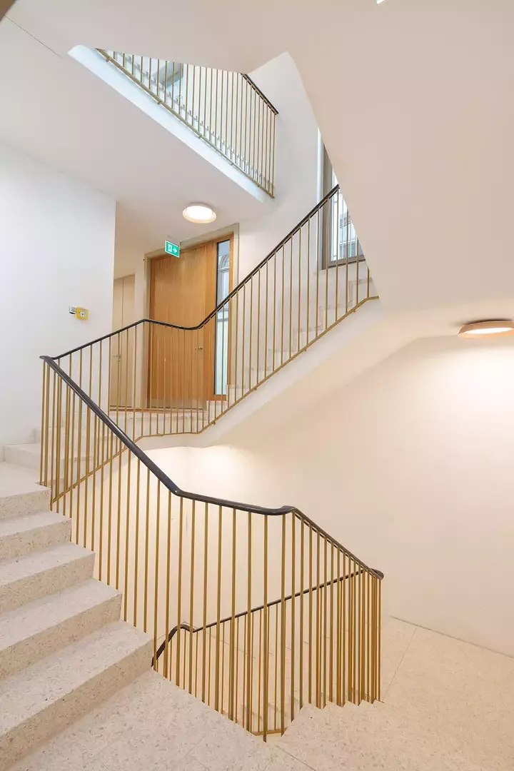 L’ élégante cage d’escalier à  l’arrière du bâtiment possède une main courante sculpturelle.