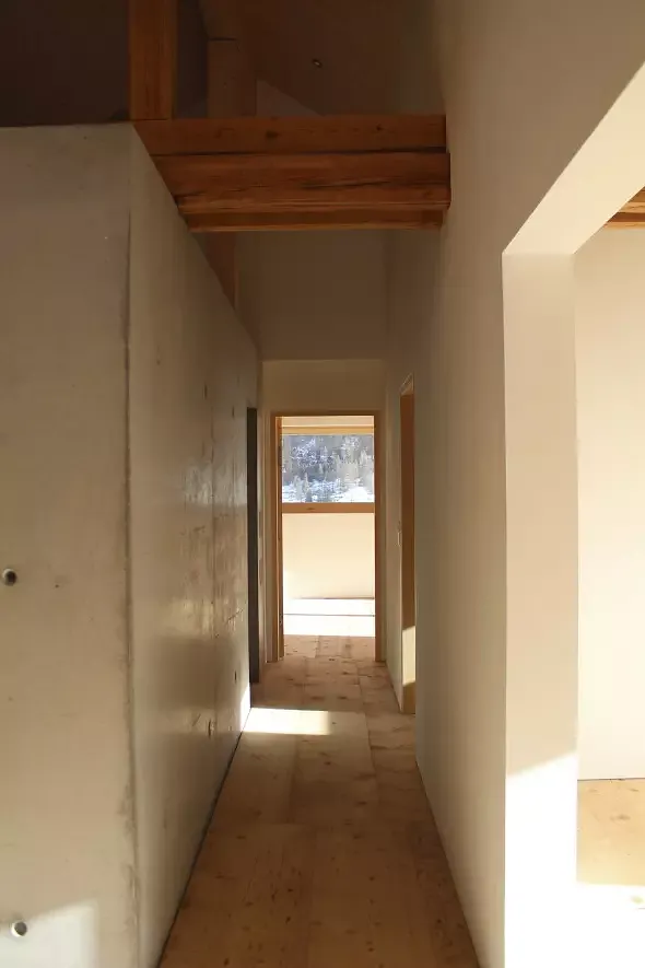 dachgeschoss mit betonkern und bestehender dachkonstruktion. die bodenbretter des bestehenden heuraumboden wurden gehobelt und wieder eingebaut.