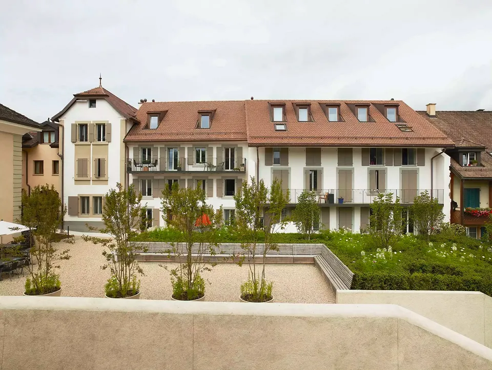 Die Schaffung eines Gartenraums sorgt für einen schlichten und eleganten Durchgang zwischen den renovierten Gebäuden. Im Hintergrund: La Passade, La Forge und L’Ancienne Poste