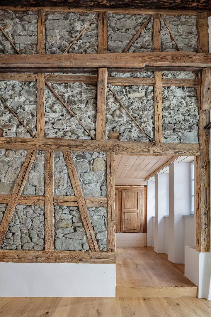 Freiliegendes Fachwerk mit Bruchsteinfüllung, im Hintergrund historische Brettertür.