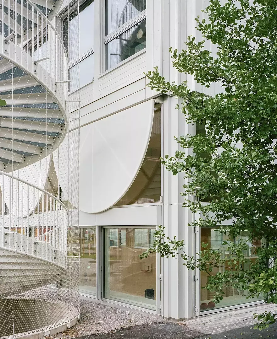 Des panneaux de façade textiles semi-circulaires servent à faire de l'ombre.