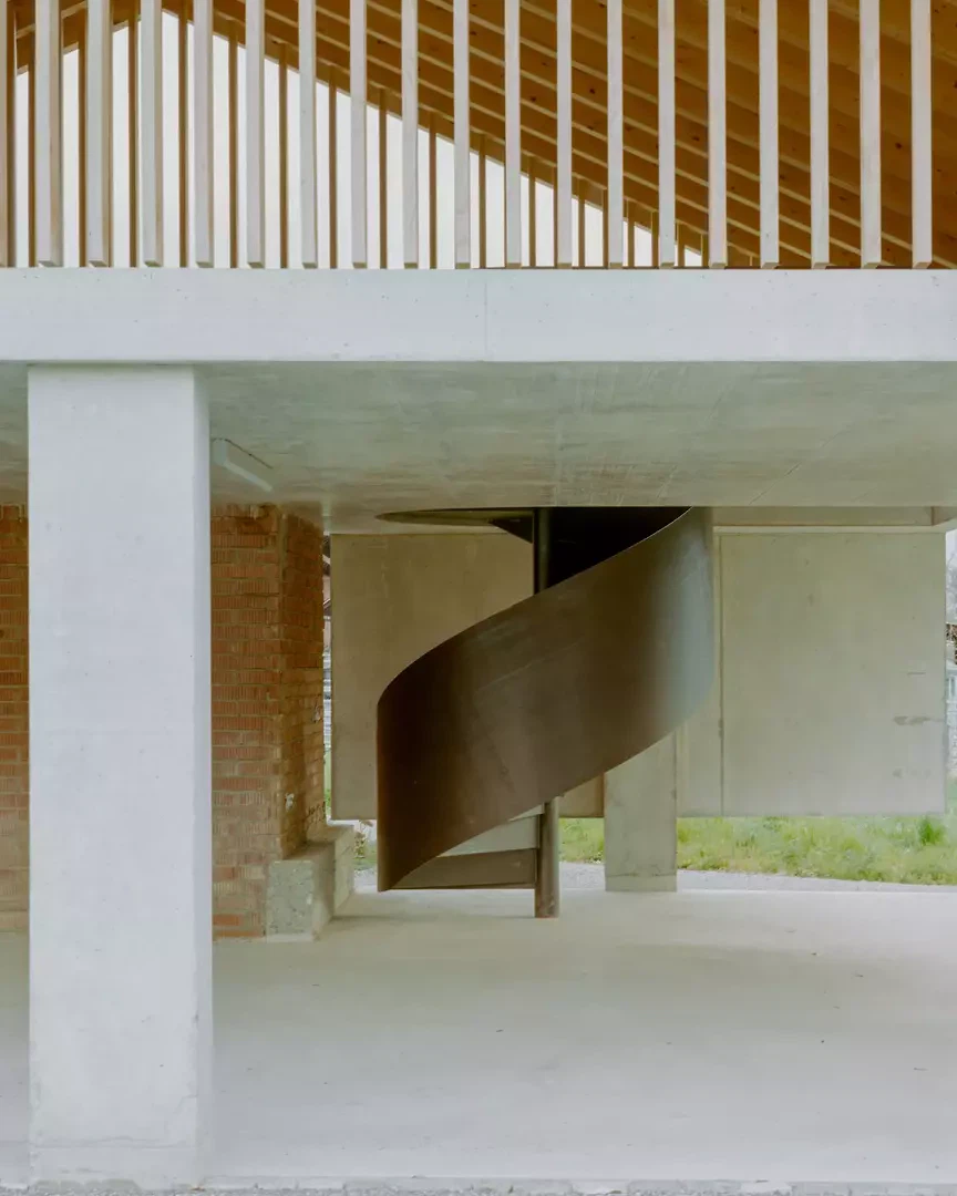 Spindeltreppe als skulpturales Element im offenen Raum des Nebengebäudes.